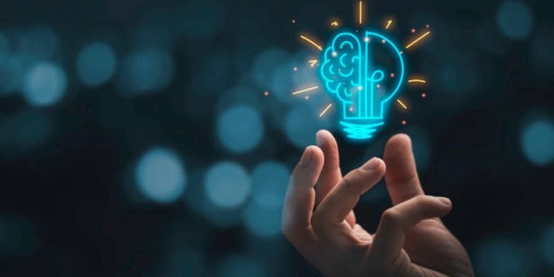 Hand holding drawing virtual lightbulb with brain on bokeh background for creative and smart thinking idea concep